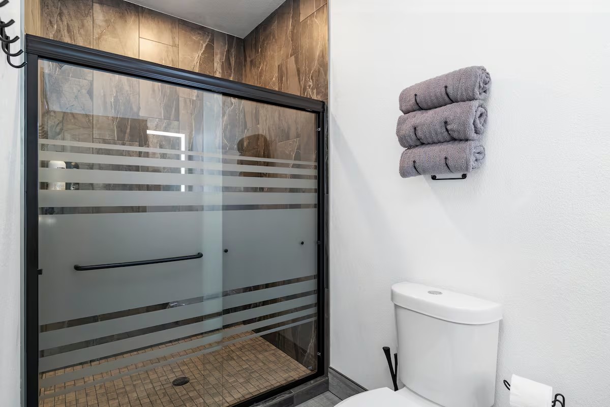 Glass-panel walk-in shower with towels