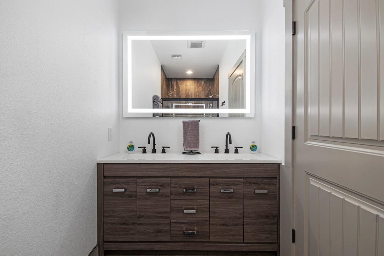 Double vanity — glass-panel walk-in shower visible in mirror