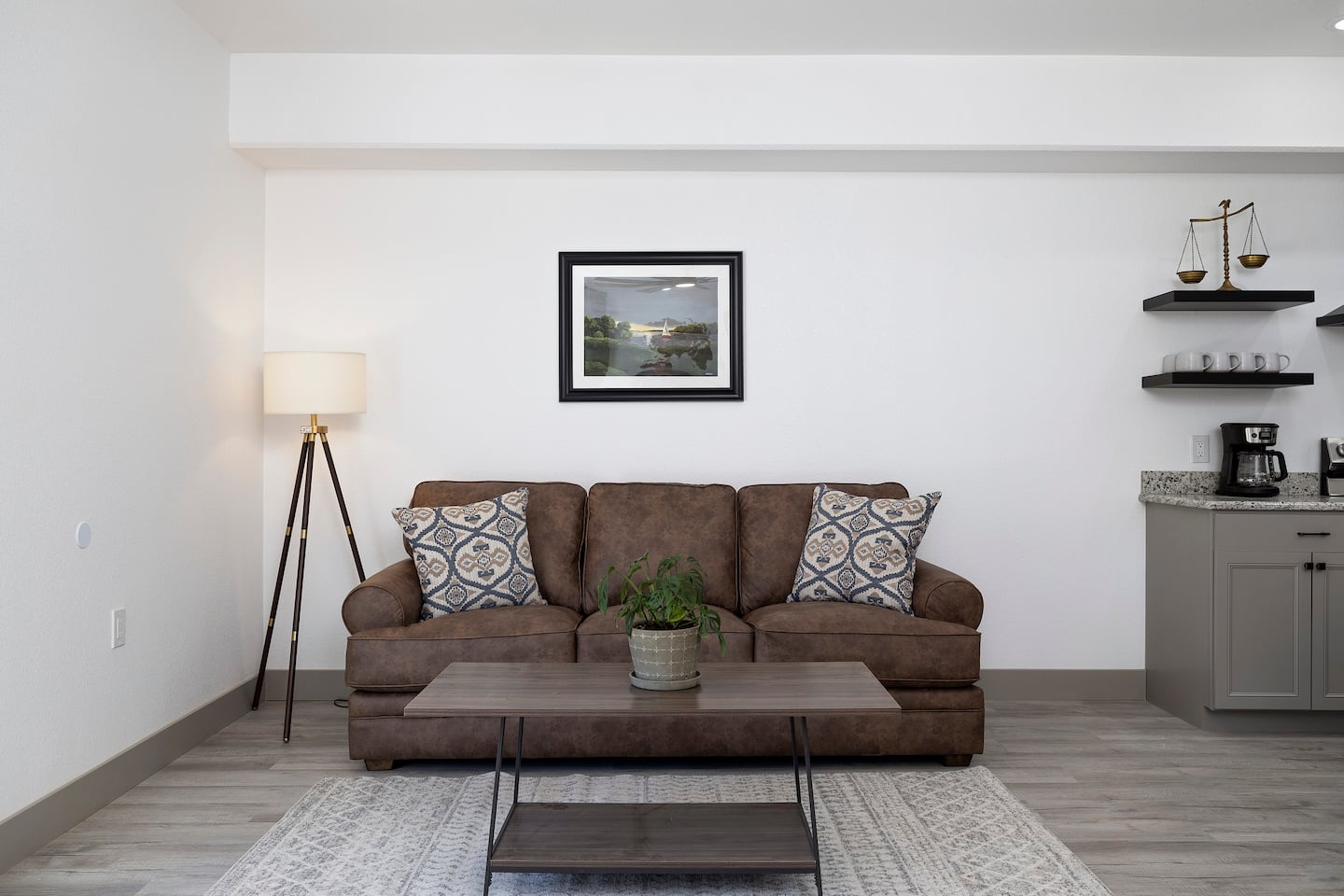 Brown couch with sailboat painting